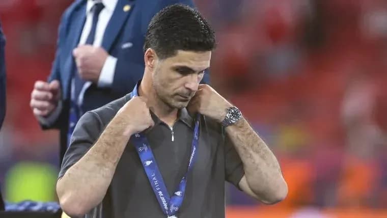 Entrenador ajustándose la medalla en el campo