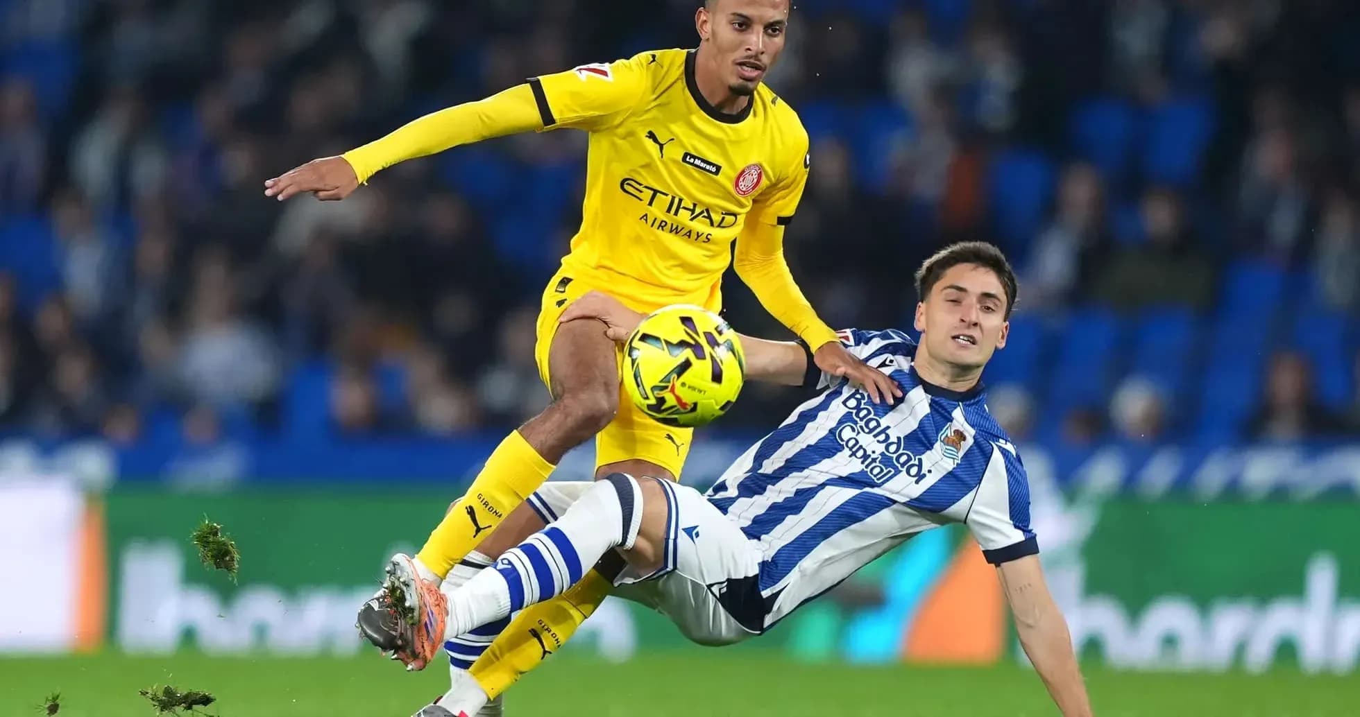 Jugador de Girona desafiando a un jugador de Real Sociedad