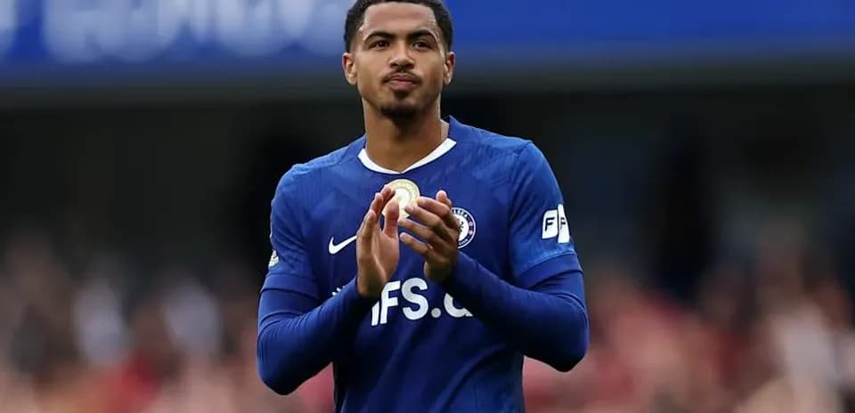 Jugador aplaudiendo con camiseta azul en el estadio