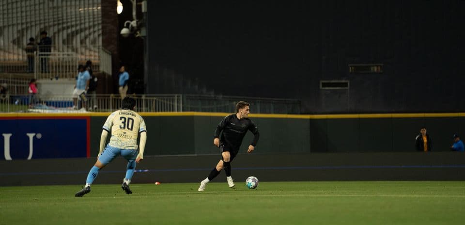 Jugador corriendo con balón durante el partido