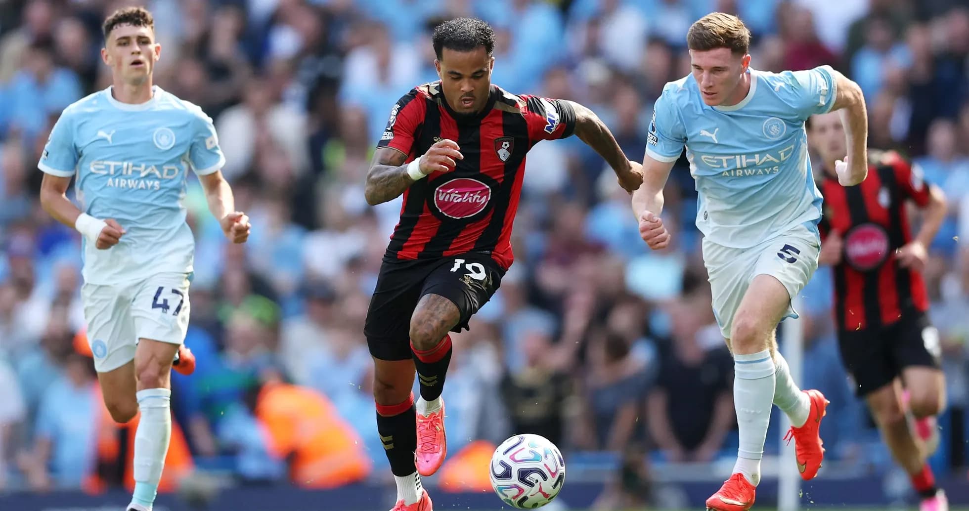Jugador de Bournemouth driblando entre defensores de Manchester City