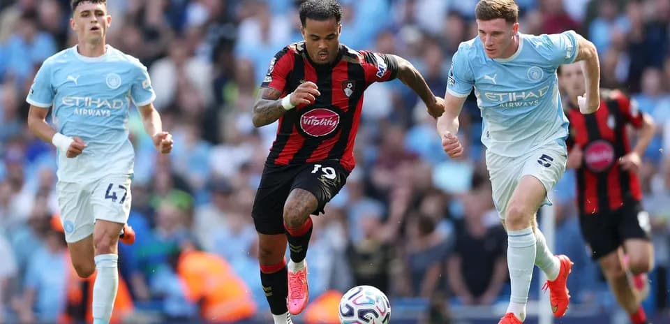 Jugador de Bournemouth driblando entre defensores de Manchester City