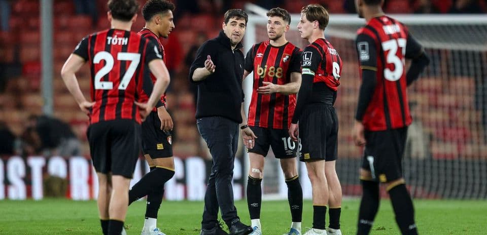 Entrenador hablando con jugadores del Bournemouth en el campo