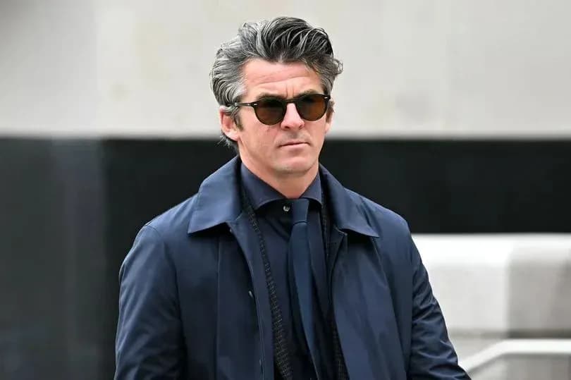 Hombre con gafas de sol y abrigo oscuro caminando