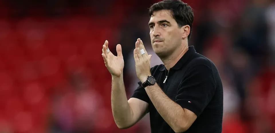 Entrenador aplaudiendo en el campo de fútbol