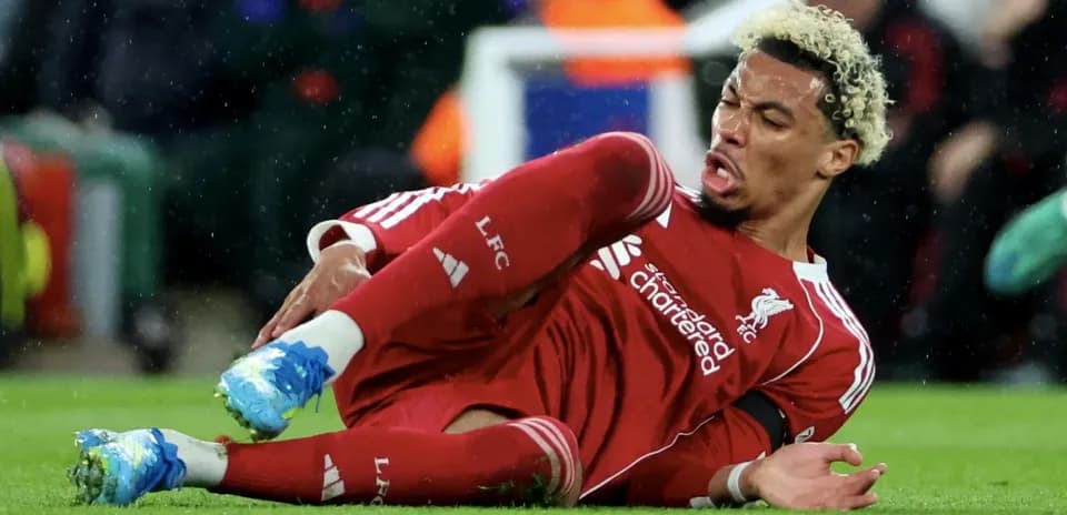 Jugador de Liverpool caído en el campo tras una falta