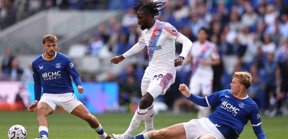 Jugador de Crystal Palace driblando entre dos rivales de Everton