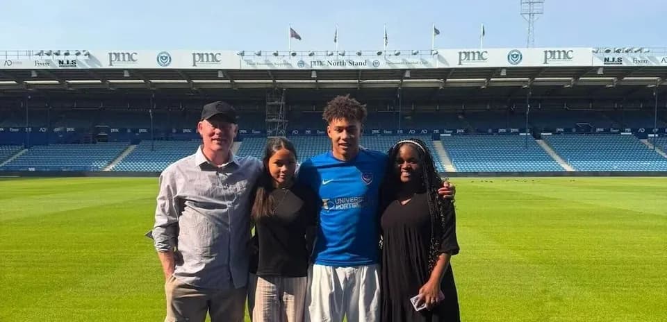 Cuatro personas posando en el estadio de fútbol