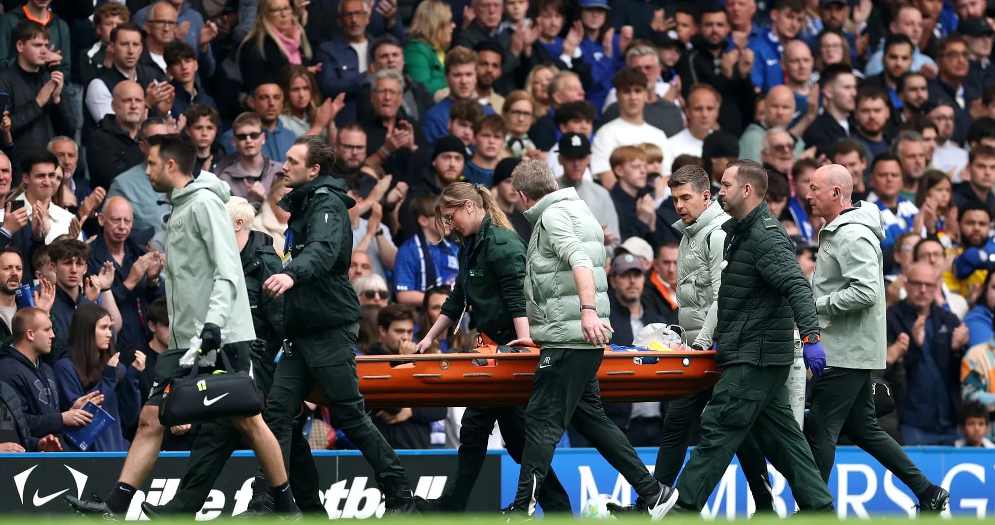 Equipo médico trasladando a un jugador en camilla