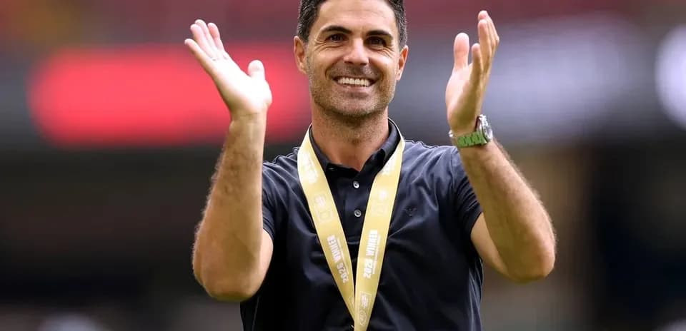 Entrenador aplaudiendo con medalla en el cuello