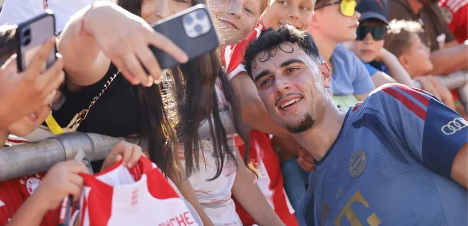 Jugador sonriendo con fans y autógrafos después del partido