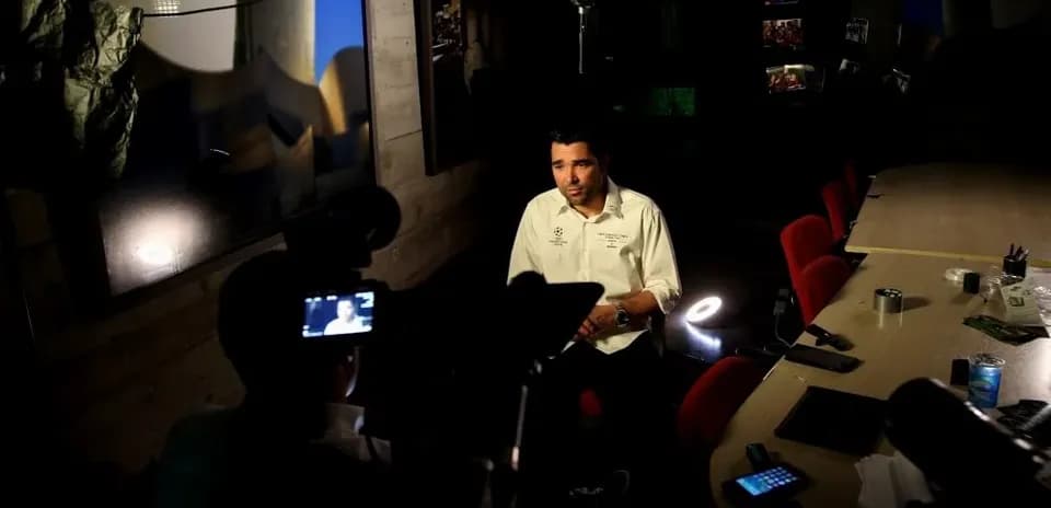 Entrevista en estudio con hombre sentado frente cámara