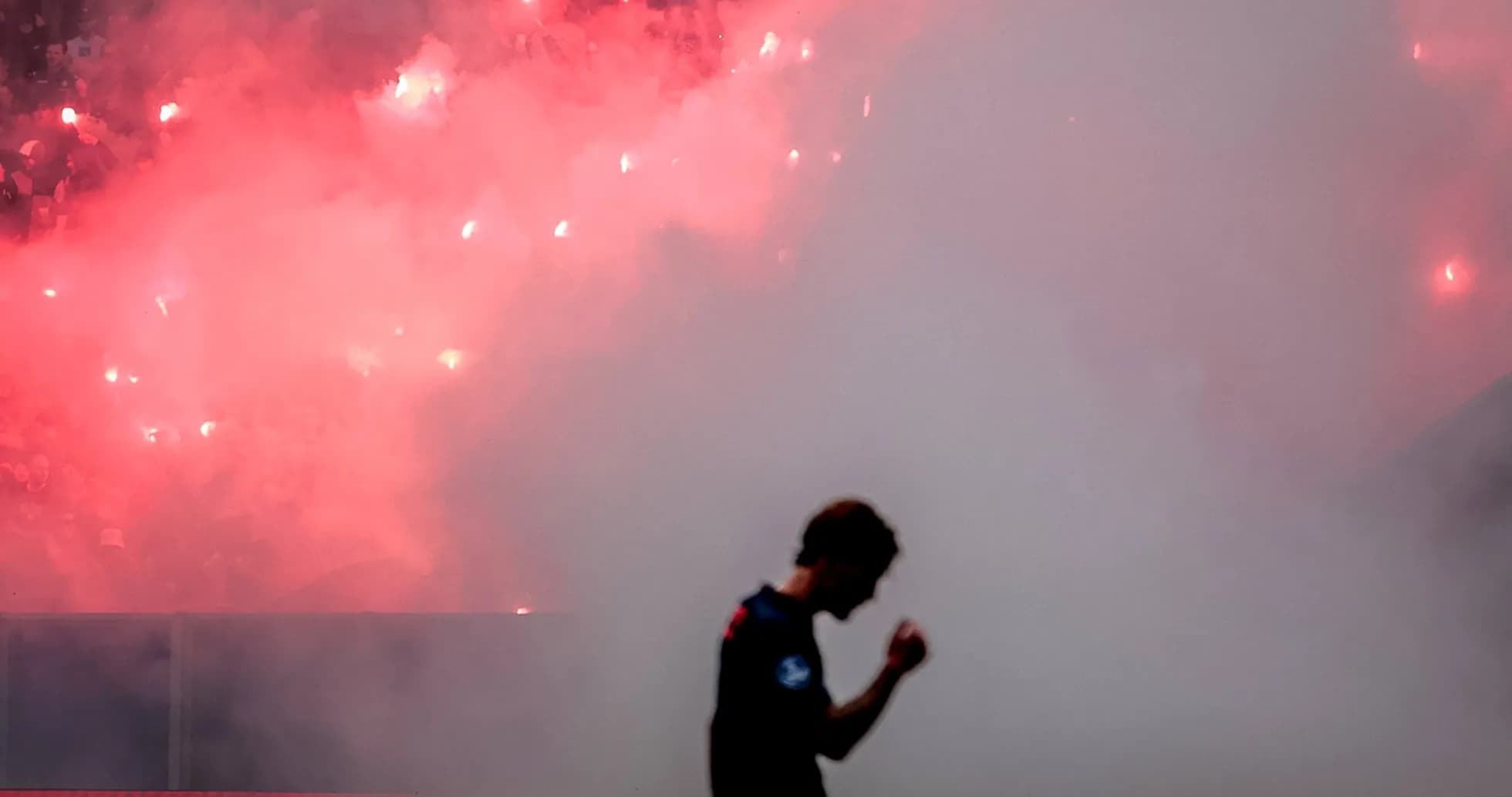 Jugador celebrando con humo de bengalas de fondo