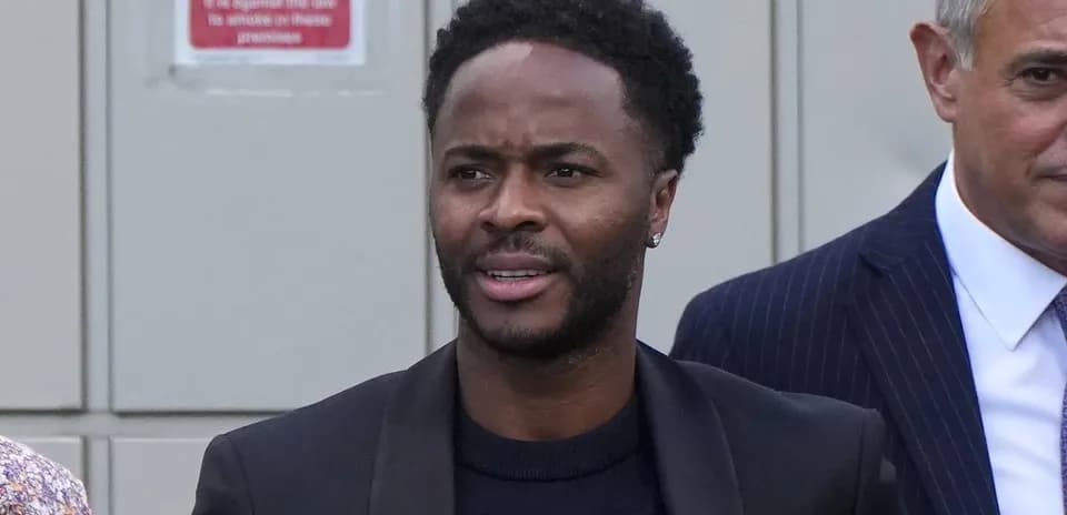 Hombre con chaqueta negra caminando junto a otro hombre