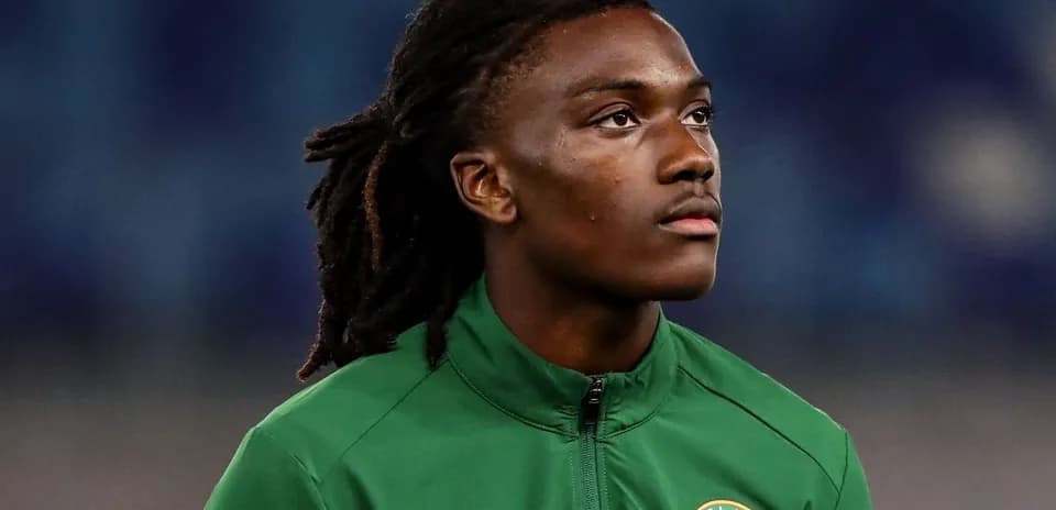 Jugador de fútbol con chaqueta verde mirando hacia arriba