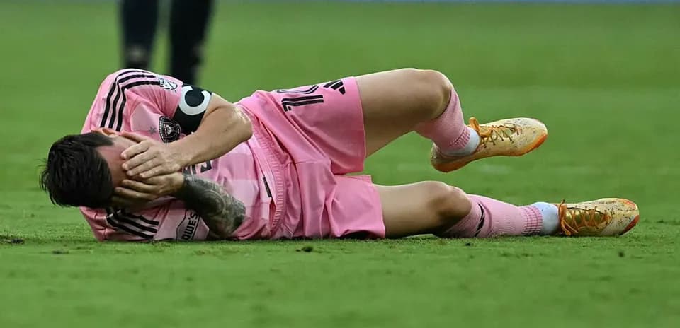 Jugador caído en el campo con uniforme rosa