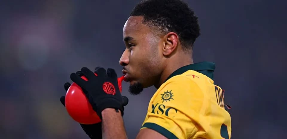 Jugador soplando en balón rojo durante partido