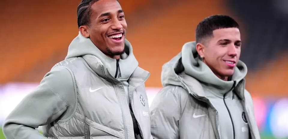 Dos jugadores sonriendo durante calentamiento en campo
