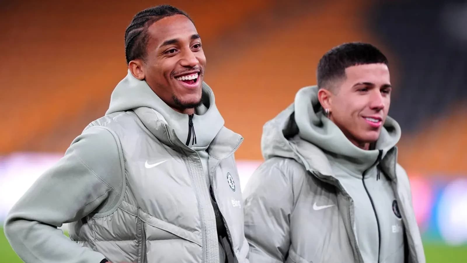 Dos jugadores sonriendo durante calentamiento en campo