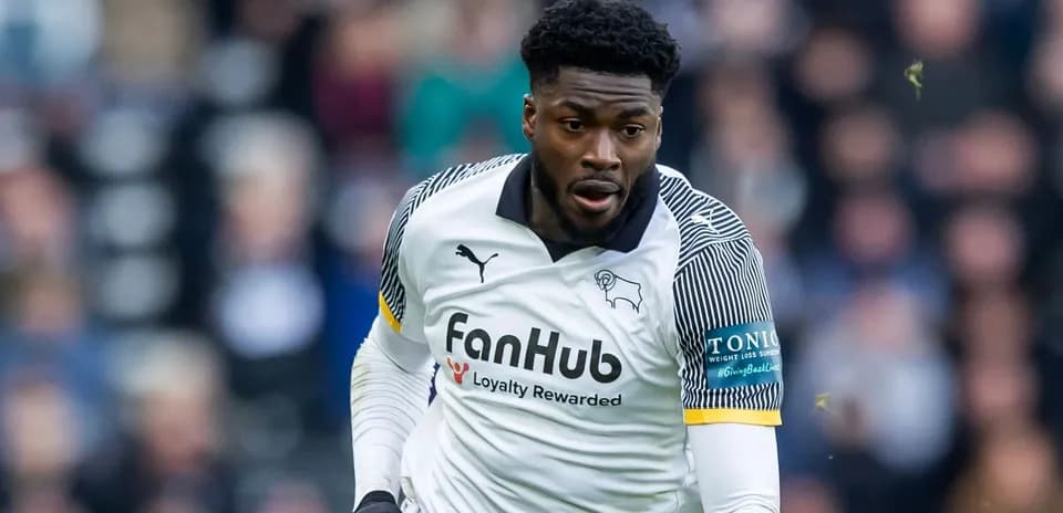 Jugador de fútbol corriendo en camiseta de Derby County