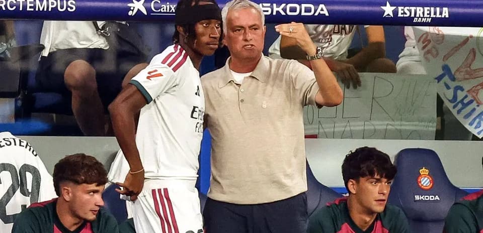 Entrenador explicando tácticas a jugador en banquillo
