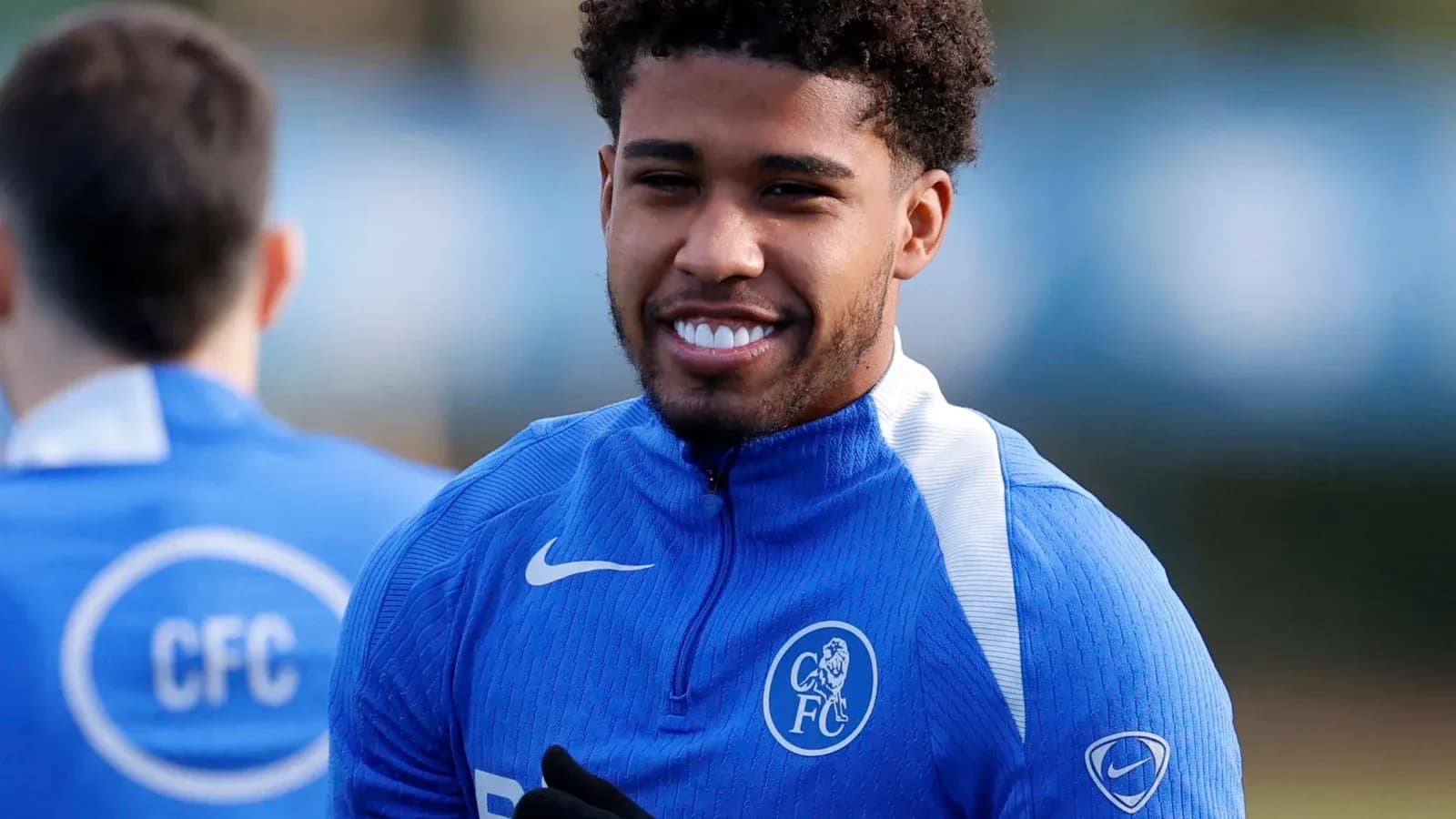 Jugador sonriendo durante entrenamiento en camiseta azul