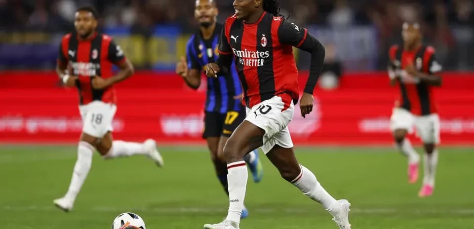 Jugador de AC Milan corriendo con el balón en el campo
