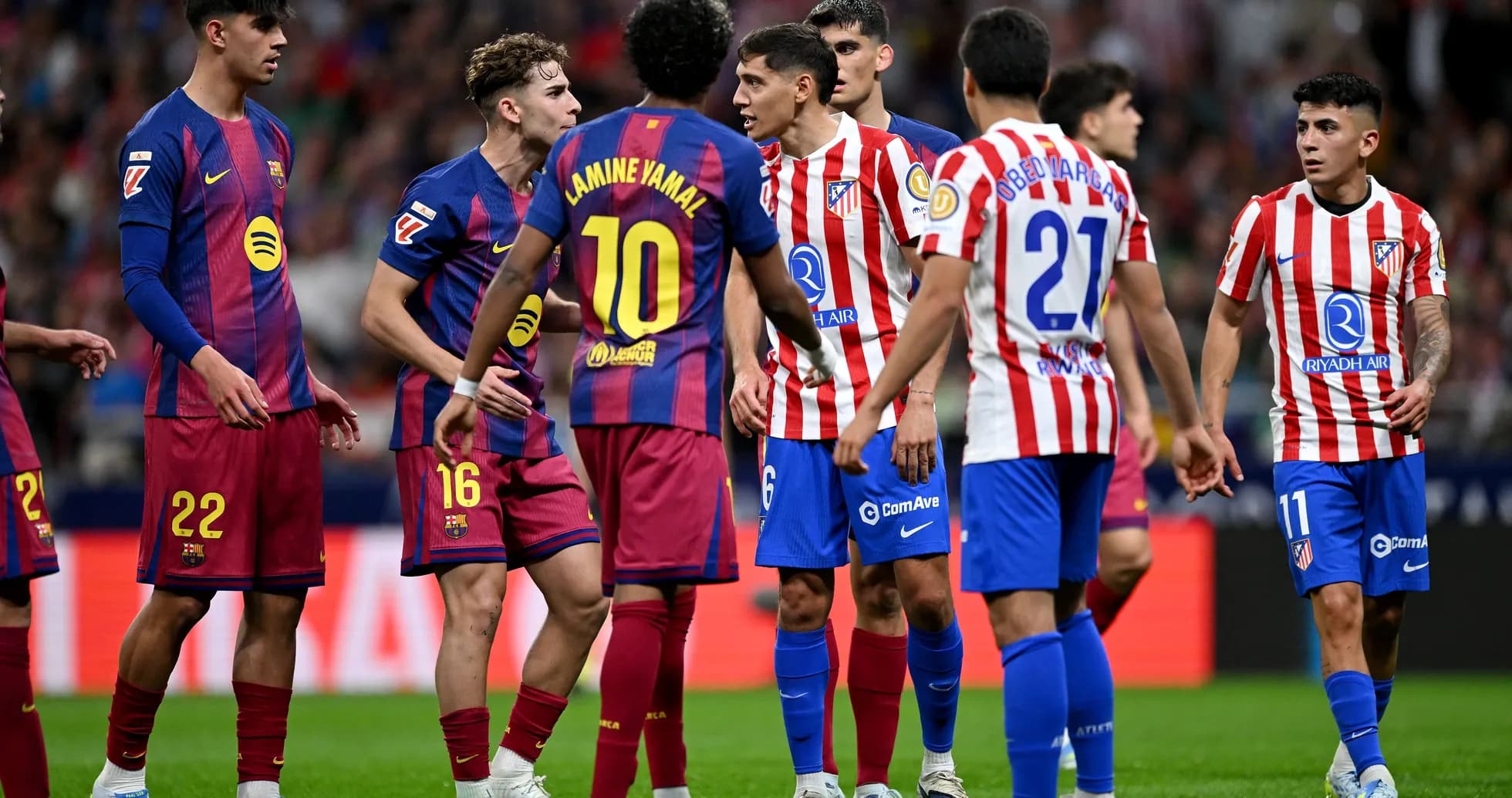 Jugadores de Barcelona y Atlético discutiendo en el campo
