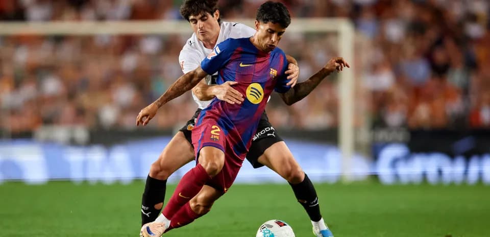 Jugador de Barcelona siendo marcado por oponente