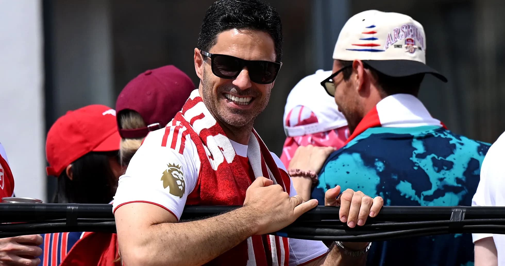 Hombre sonriente con bufanda en evento deportivo