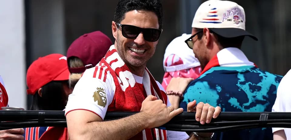 Hombre sonriente con bufanda en evento deportivo