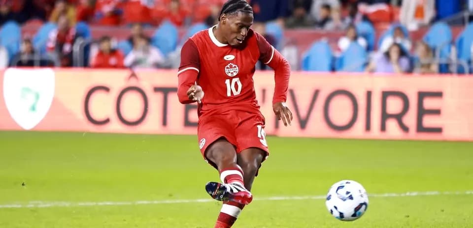 Jugador de Canadá pateando un balón en el campo