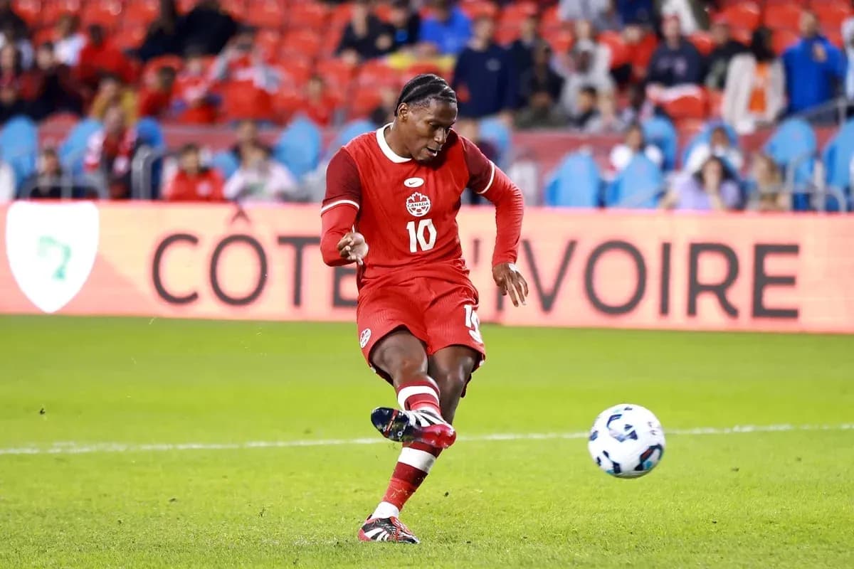 Jugador de Canadá pateando un balón en el campo