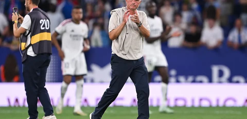 Entrenador aplaudiendo durante el partido en estadio