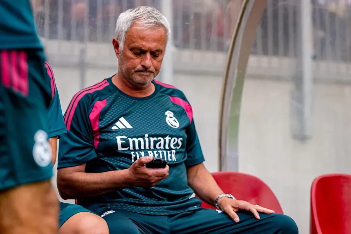 Entrenador de Real Madrid sentado con teléfono móvil