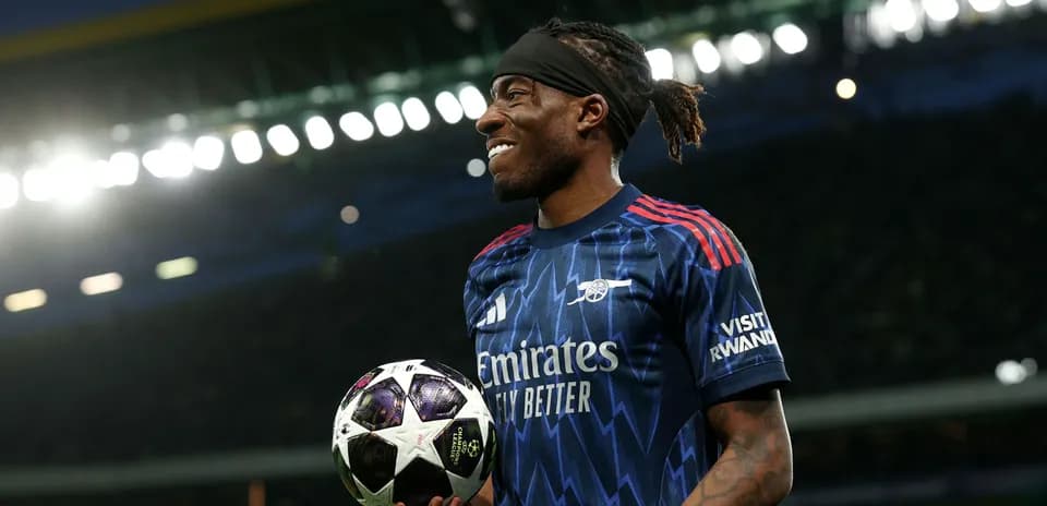 Jugador sosteniendo un balón de fútbol en el campo