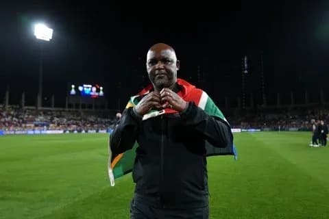Entrenador con bandera sudafricana en el campo
