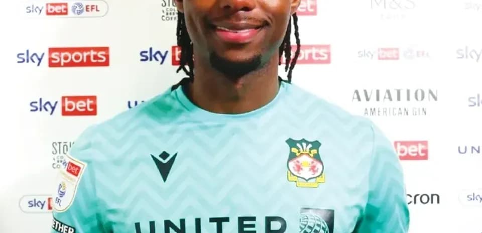 Jugador sonriendo en camiseta de portero con patrocinadores