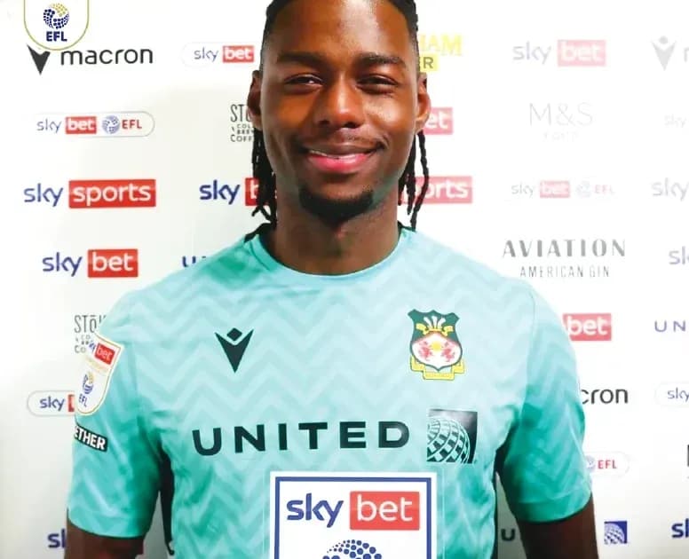 Jugador sonriendo en camiseta de portero con patrocinadores
