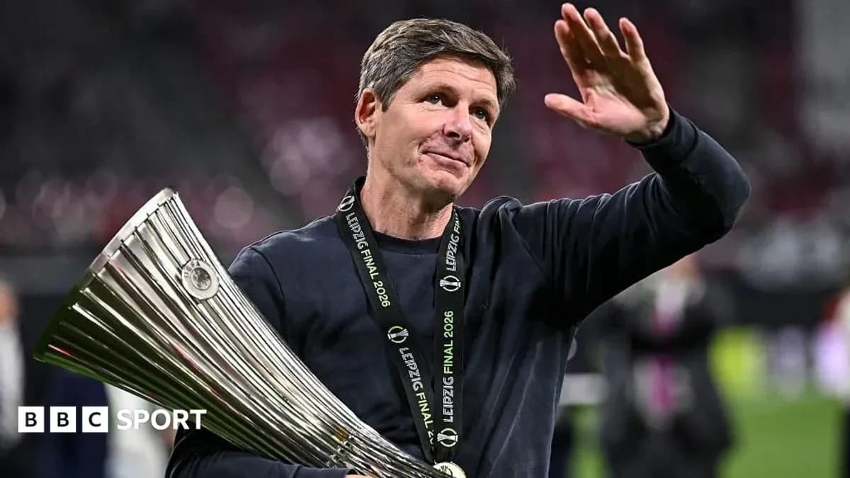 Entrenador sosteniendo trofeo y saludando tras la victoria