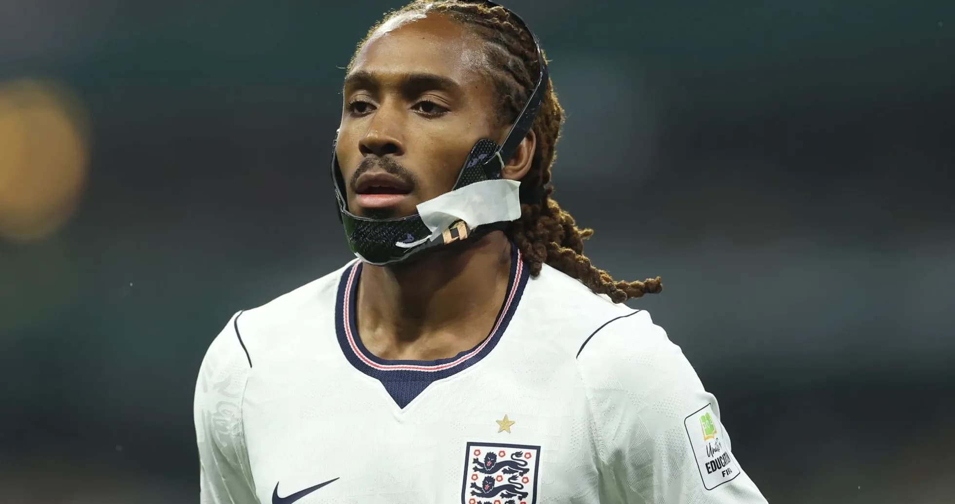 Jugador con máscara en camiseta de Inglaterra durante partido