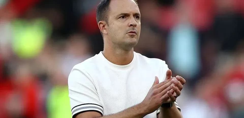 Entrenador aplaudiendo en el banquillo del partido