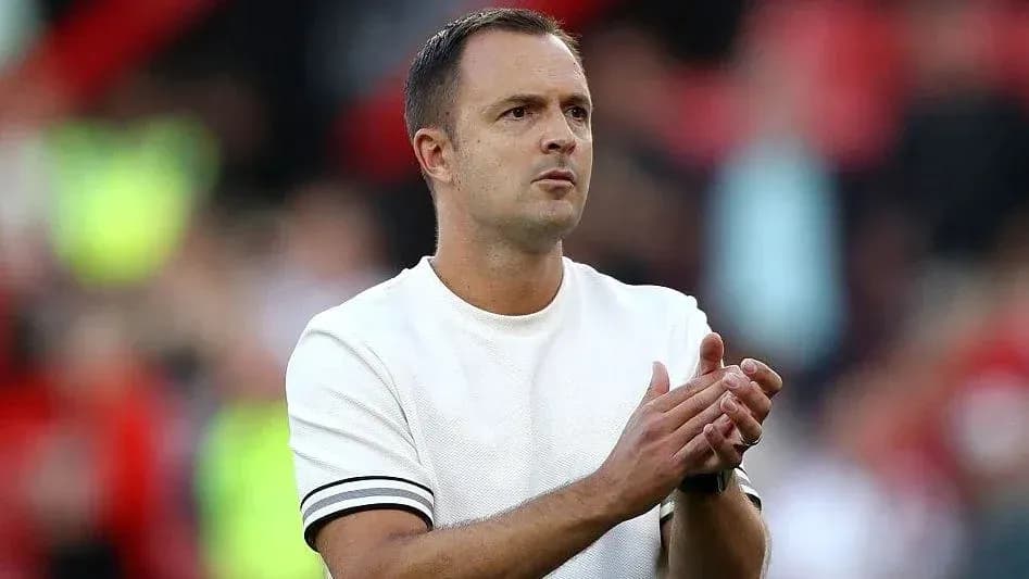 Entrenador aplaudiendo en el banquillo del partido