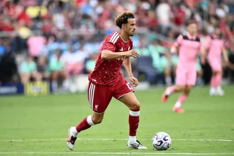 Jugador de Liverpool corriendo con el balón en el campo