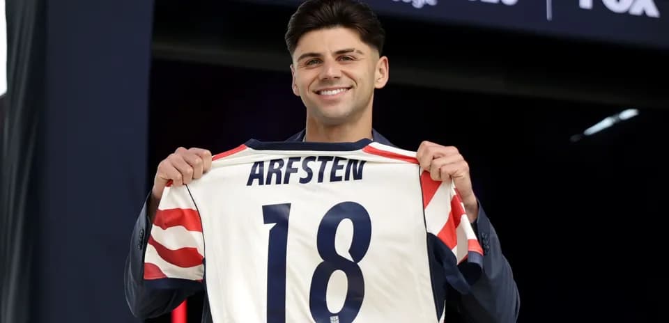 Jugador sosteniendo camiseta con nombre y número