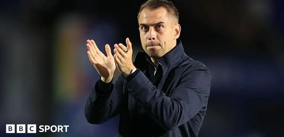 Entrenador aplaudiendo en el banquillo del partido