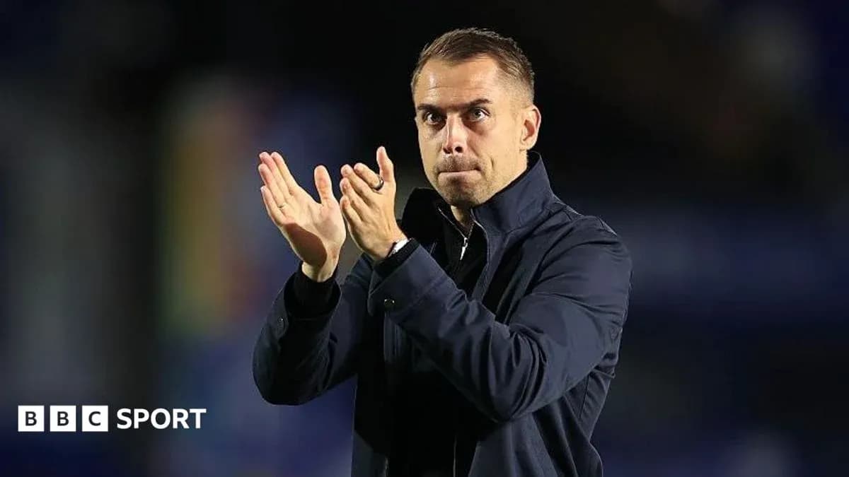 Entrenador aplaudiendo en el banquillo del partido