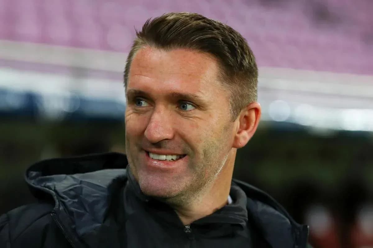 Entrenador sonriendo en el campo de fútbol