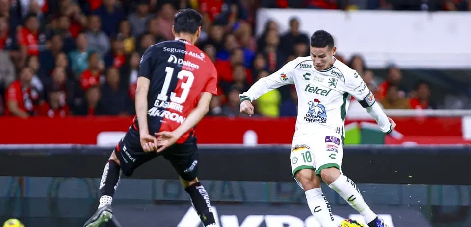 Jugador de León driblando a defensor de Atlas