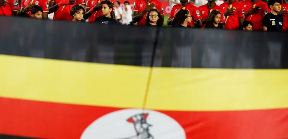 Jugadores de Uganda alineados con la bandera nacional